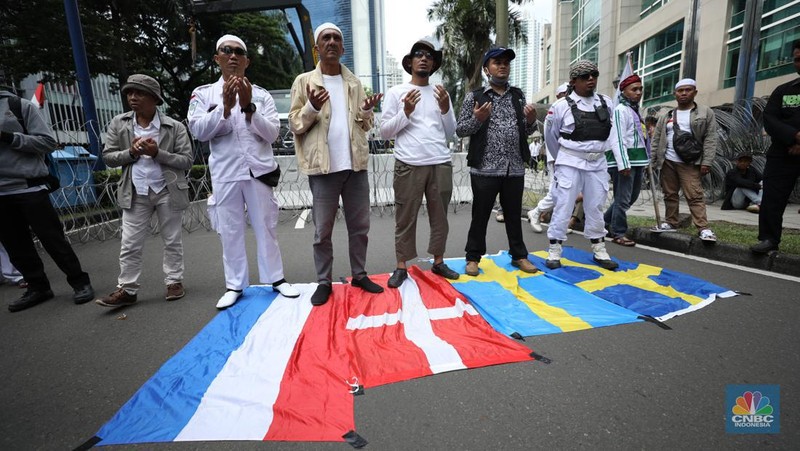 Sejumlah kelompok masyarakat yang tergabung dalam Aksi Bela Al-Quran menggelar aksi injak bendera Denmark, Swedia, dan Belanda di depan Kantor Kedutaan Besar (Kedubes) Swedia, Jakarta, Senin (30/1/2023). Peserta aksi mengecam tindakan Rasmus lantaran dianggap menista agama Islam dengan membakar Al-Qur'an. (CNBC Indonesia/Tri Susilo)