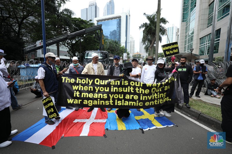 Warga Yaman mengangkat plakat dan salinan Alquran selama protes terhadap pembakaran salinan Alquran oleh seorang politisi Swedia. (dpa/picture alliance via Getty Images)