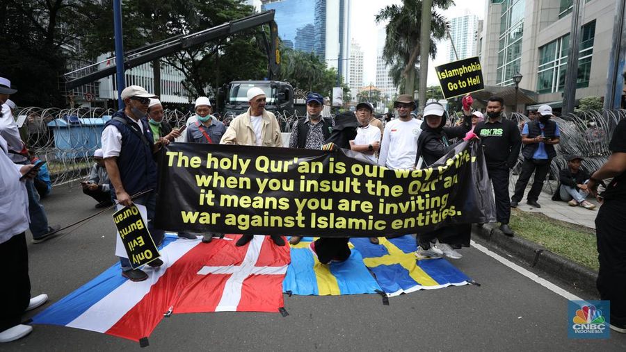Warga Yaman mengangkat plakat dan salinan Alquran selama protes terhadap pembakaran salinan Alquran oleh seorang politisi Swedia. (dpa/picture alliance via Getty Images)