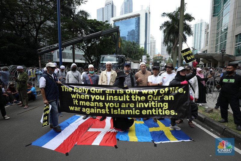 Sejumlah kelompok masyarakat yang tergabung dalam Aksi Bela Al-Quran menggelar aksi injak bendera Denmark, Swedia, dan Belanda di depan Kantor Kedutaan Besar (Kedubes) Swedia, Jakarta, Senin (30/1/2023). Peserta aksi mengecam tindakan Rasmus lantaran dianggap menista agama Islam dengan membakar Al-Qur'an. (CNBC Indonesia/Tri Susilo)