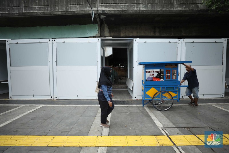 Warga melewati kios pedagang kaki lima di kawasan Tugu Proklamasi, Jakarta, Senin (30/1/2023). Warga melewati kios pedagang kaki lima di kawasan Tugu Proklamasi, Jakarta, Senin (30/1/2023). Pemerintah menyediakan 92 kios berukuran 2 x 2 meter untuk pedagang kaki lima di kawasan tersebut. (CNBC Indonesia/Tri Susilo)