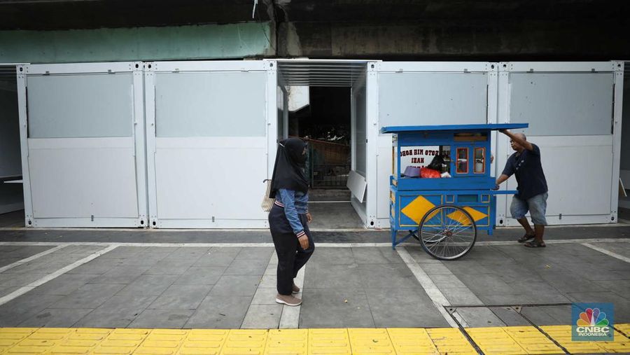 Warga melewati kios pedagang kaki lima di kawasan Tugu Proklamasi, Jakarta, Senin (30/1/2023). Pemerintah menyediakan 92 kios berukuran 2 x 2 meter untuk pedagang kaki lima di kawasan tersebut. (CNBC Indonesia/Tri Susilo)