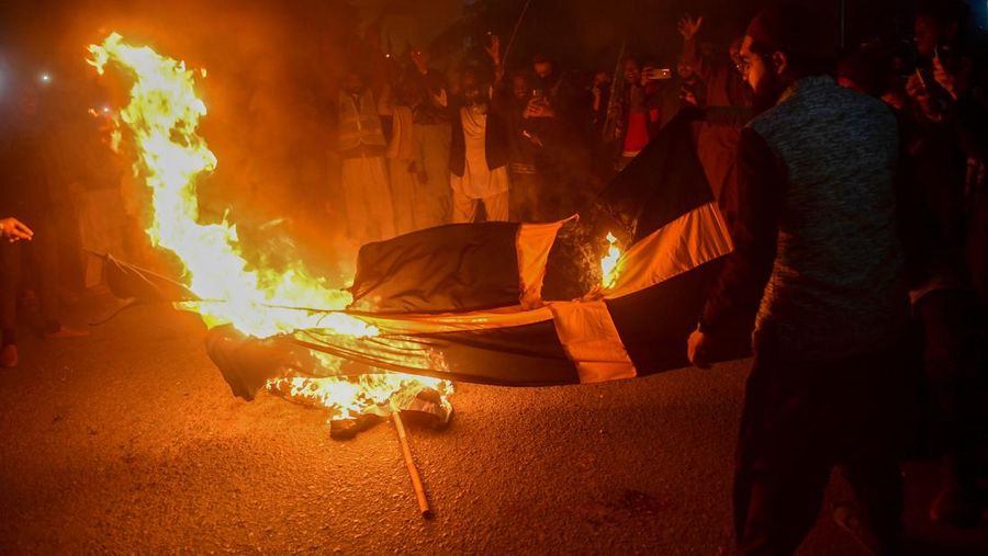 Warga Yaman mengangkat plakat dan salinan Alquran selama protes terhadap pembakaran salinan Alquran oleh seorang politisi Swedia. (dpa/picture alliance via Getty Images)