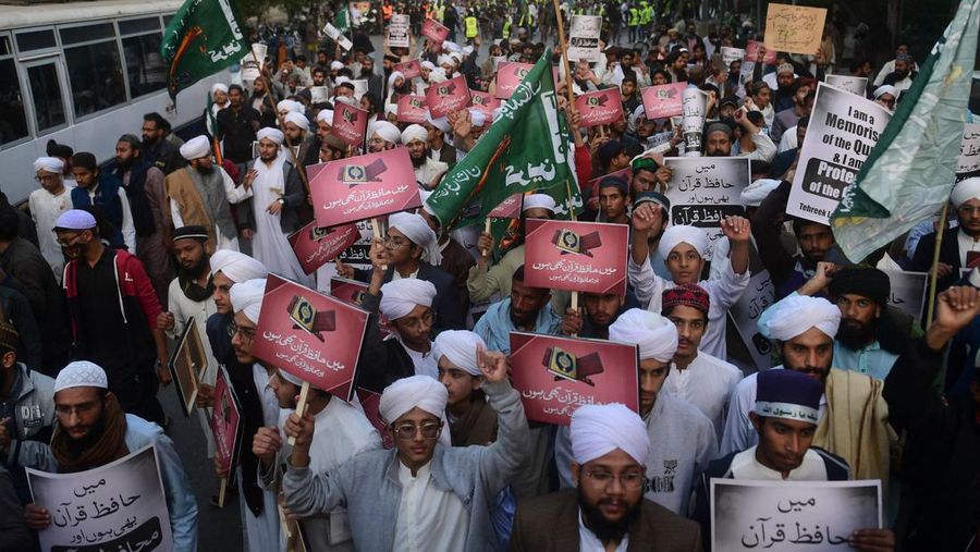 Warga Yaman mengangkat plakat dan salinan Alquran selama protes terhadap pembakaran salinan Alquran oleh seorang politisi Swedia. (dpa/picture alliance via Getty Images)