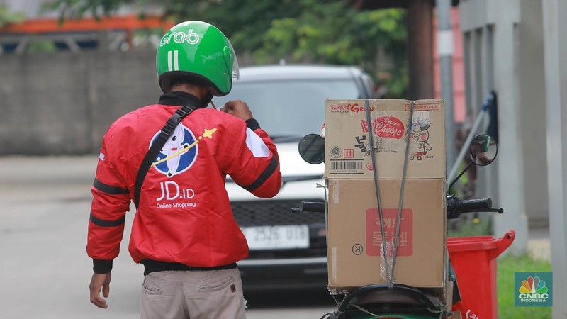 Kurir JDid melintas di depan gudang JDid,Marunda, Jakarta, (31/1/2023). Pantauan CNBC Indonesia di lokasi terlihat sejumlah kurir menaiki barang pesanan ke mobil. (CNBC Indonesia/ Muhammad Sabki)