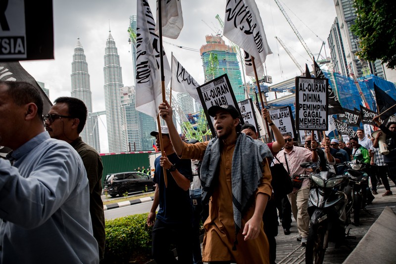 Warga Yaman mengangkat plakat dan salinan Alquran selama protes terhadap pembakaran salinan Alquran oleh seorang politisi Swedia. (dpa/picture alliance via Getty Images)