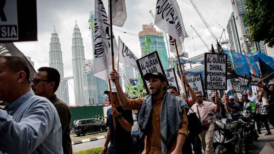Warga Yaman mengangkat plakat dan salinan Alquran selama protes terhadap pembakaran salinan Alquran oleh seorang politisi Swedia. (dpa/picture alliance via Getty Images)