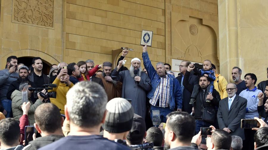 Warga Yaman mengangkat plakat dan salinan Alquran selama protes terhadap pembakaran salinan Alquran oleh seorang politisi Swedia. (dpa/picture alliance via Getty Images)