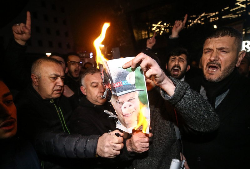 Warga Yaman mengangkat plakat dan salinan Alquran selama protes terhadap pembakaran salinan Alquran oleh seorang politisi Swedia. (dpa/picture alliance via Getty Images)