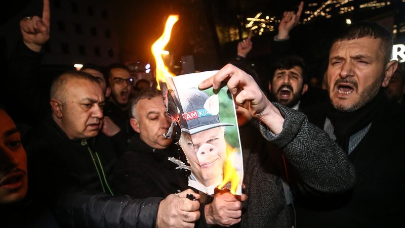 Warga Yaman mengangkat plakat dan salinan Alquran selama protes terhadap pembakaran salinan Alquran oleh seorang politisi Swedia. (dpa/picture alliance via Getty Images)