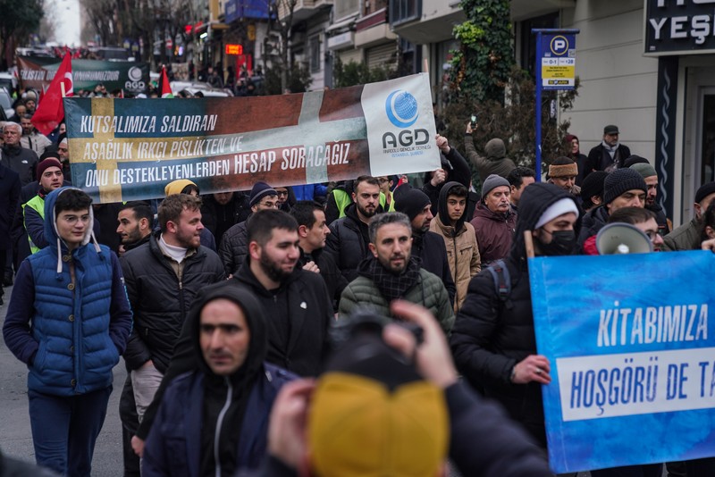 Warga Yaman mengangkat plakat dan salinan Alquran selama protes terhadap pembakaran salinan Alquran oleh seorang politisi Swedia. (dpa/picture alliance via Getty Images)