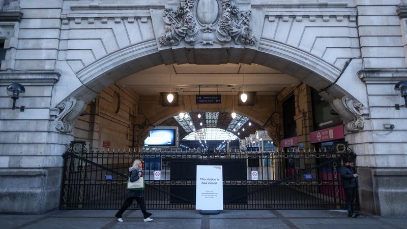 A commuter passes a closed entrance to London Victoria railway station during joint strike action by train drivers, teachers, university staff and civil servants, in London, UK, on Wednesday, Feb. 1, 2023. The day of coordinated industrial action is expected to be Britains most severe day of strikes for over a decade, piling pressure on Prime Minister Rishi Sunaks Conservative administration to resolve disputes with public sector workers by making more generous offers on pay. Photographer: Chris Ratcliffe/Bloomberg via Getty Images
