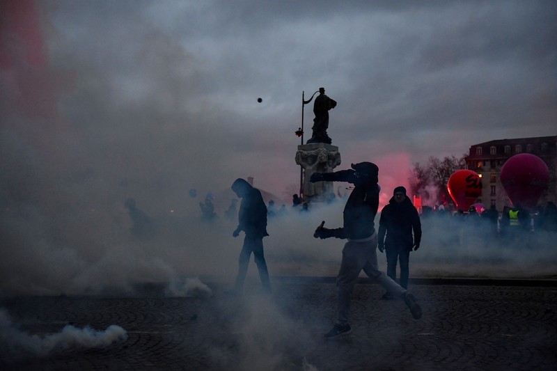 Para pengunjuk rasa bentrok dengan polisi di Place Vauban pada rapat umum pada hari kedua pemogokan nasional dan protes atas usulan reformasi pensiun pemerintah, di Paris pada 31 Januari 2023. Para pengunjuk rasa bentrok dengan polisi di Place Vauban pada rapat umum pada hari kedua pemogokan nasional dan protes atas usulan reformasi pensiun pemerintah, di Paris pada 31 Januari 2023. - Prancis bersiap menghadapi pemblokiran transportasi besar, dengan pemogokan massal dan protes ditetapkan menghantam negara itu untuk kedua kalinya dalam sebulan sebagai keberatan atas peningkatan usia pensiun yang direncanakan dari 62 menjadi 64. Pada 19 Januari, sekitar 1,1 juta menyuarakan penentangan mereka terhadap perubahan yang diusulkan -- protes terbesar sejak terakhir putaran besar reformasi pensiun pada tahun 2010. (JULIEN DE ROSA/AFP via Getty Images)