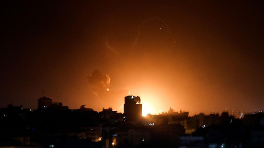 Api dan asap mengepul di atas gedung-gedung di Kota Gaza saat Israel melancarkan serangan udara ke kantong Palestina pada awal 2 Februari 2023 - Israel melakukan serangan udara di Jalur Gaza tengah beberapa jam setelah mencegat roket yang ditembakkan dari wilayah Palestina, menurut wartawan AFP dan saksi pada 2 Februari 2023. (MOHAMMED ABED/AFP via Getty Images)