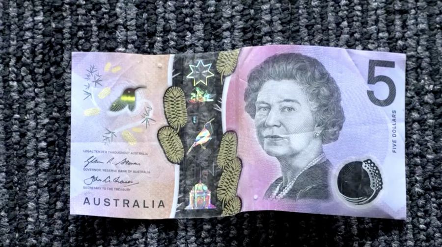 This photo illustration taken in Hong Kong on February 2, 2023 shows the Australian $5 banknote. - Australia's central bank announced on February 2, 2023 it will erase the British monarch from its banknotes, replacing the late Queen Elizabeth II's image on its $5 note with a design honouring Indigenous culture. (Photo by Mladen ANTONOV / AFP) (Photo by MLADEN ANTONOV/AFP via Getty Images)