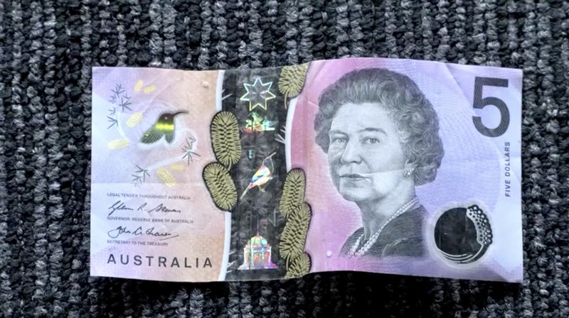 This photo illustration taken in Hong Kong on February 2, 2023 shows the Australian $5 banknote. - Australia's central bank announced on February 2, 2023 it will erase the British monarch from its banknotes, replacing the late Queen Elizabeth II's image on its $5 note with a design honouring Indigenous culture. (Photo by Mladen ANTONOV / AFP) (Photo by MLADEN ANTONOV/AFP via Getty Images)