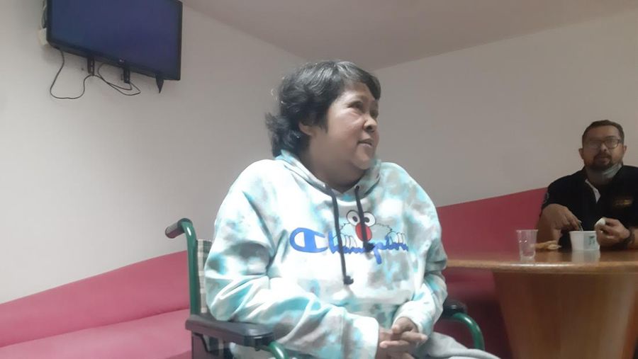 Suti Karno memakai kaki palsu.