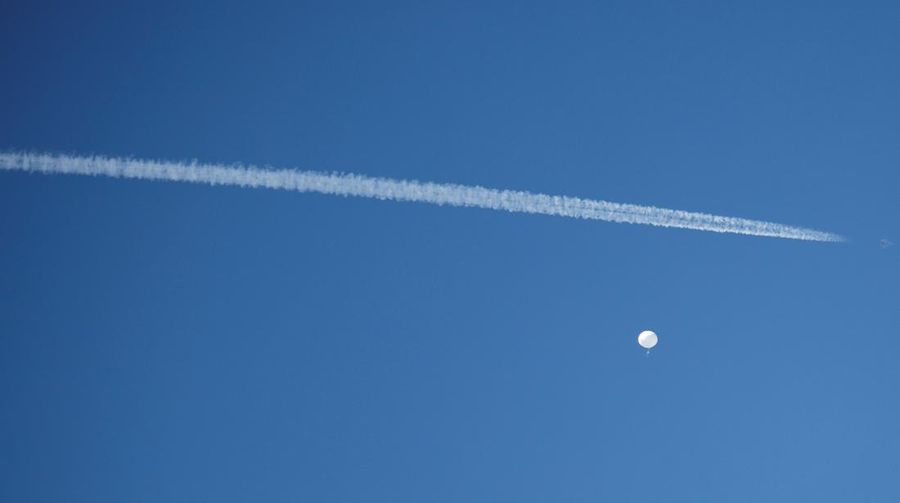 Sebuah jet terbang dengan balon mata-mata China yang dicurigai saat mengapung di lepas pantai di Pantai Surfside, Carolina Selatan, AS 4 Februari 2023. (REUTERS/Randall Hill)