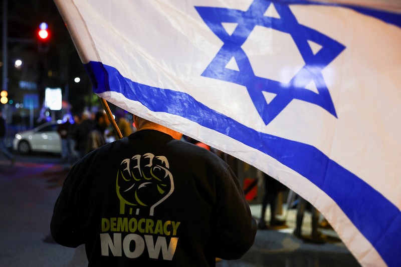 Warga Israel memegang bendera saat mereka memprotes koalisi sayap kanan baru Perdana Menteri Benjamin Netanyahu dan usulan reformasi peradilan untuk mengurangi kekuasaan Mahkamah Agung di Tel Aviv, Israel 4 Februari 2023. (REUTERS/Ronen Zvulun)