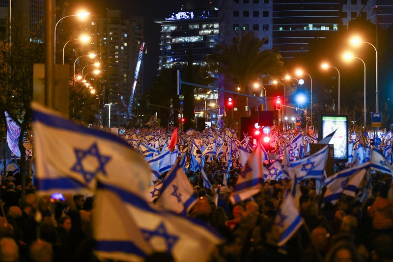 Warga Israel memegang bendera saat mereka memprotes koalisi sayap kanan baru Perdana Menteri Benjamin Netanyahu dan usulan reformasi peradilan untuk mengurangi kekuasaan Mahkamah Agung di Tel Aviv, Israel 4 Februari 2023. Warga Israel memegang bendera saat mereka memprotes koalisi sayap kanan baru Perdana Menteri Benjamin Netanyahu dan usulan reformasi peradilan untuk mengurangi kekuasaan Mahkamah Agung di Tel Aviv, Israel 4 Februari 2023. (REUTERS/Ronen Zvulun)