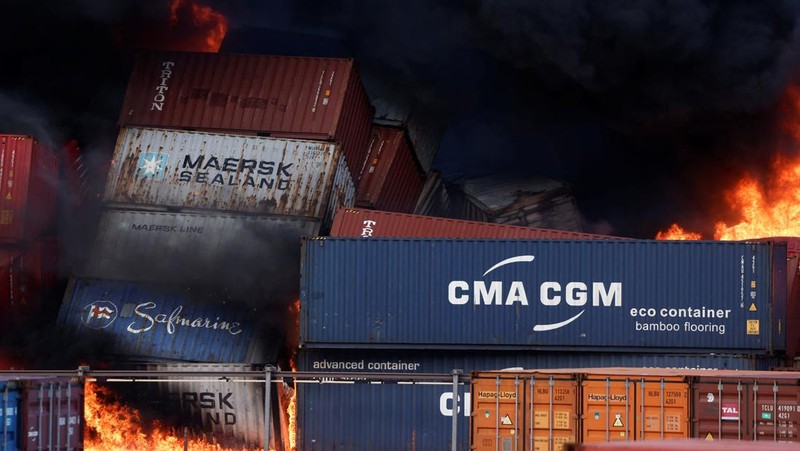 Asap mengepul dari kontainer yang terbakar di sebuah pelabuhan di kota Iskenderun yang dilanda gempa, Turki, 7 Februari 2023. (REUTERS/Benoit Tessier)
