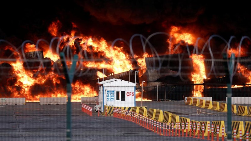 Asap mengepul dari kontainer yang terbakar di sebuah pelabuhan di kota Iskenderun yang dilanda gempa, Turki, 7 Februari 2023. (REUTERS/Benoit Tessier)