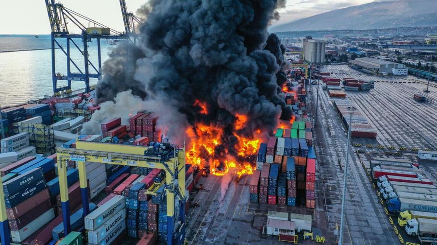Asap mengepul dari kontainer yang terbakar di sebuah pelabuhan di kota Iskenderun yang dilanda gempa, Turki, 7 Februari 2023. (REUTERS/Benoit Tessier)