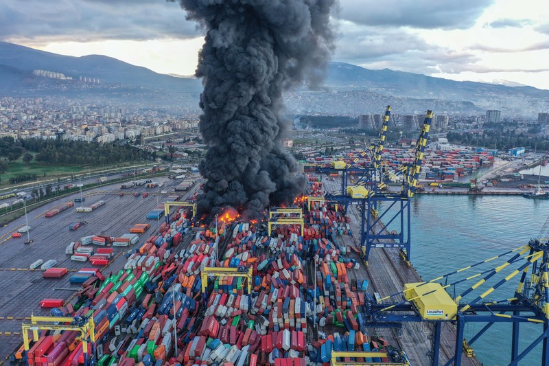 Asap mengepul dari kontainer yang terbakar di sebuah pelabuhan di kota Iskenderun yang dilanda gempa, Turki, 7 Februari 2023. Asap mengepul dari kontainer yang terbakar di sebuah pelabuhan di kota Iskenderun yang dilanda gempa, Turki, 7 Februari 2023. (REUTERS/Benoit Tessier)