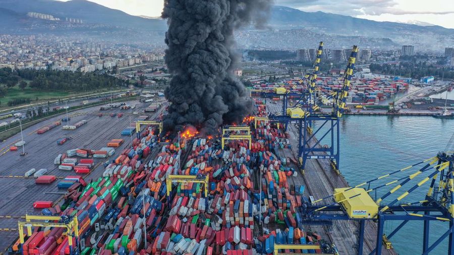 Asap mengepul dari kontainer yang terbakar di sebuah pelabuhan di kota Iskenderun yang dilanda gempa, Turki, 7 Februari 2023. (REUTERS/Benoit Tessier)
