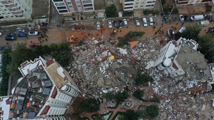 Asap mengepul dari Pelabuhan Iskenderun saat petugas penyelamat bekerja di lokasi bangunan yang runtuh pada 07 Februari 2023 di Iskenderun, Turki. Gempa berkekuatan 7,8 melanda dekat Gaziantep, Turki, pada dini hari Senin, diikuti oleh gempa berkekuatan 7,5 setelah tengah hari. Gempa tersebut menyebabkan kerusakan luas di Turki selatan dan Suriah utara dan dirasakan di negara-negara terdekat. (Burak Kara/Getty Images)