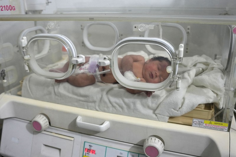 Bayi baru lahir yang ditemukan masih terikat tali pusar ke ibunya dan ditarik hidup-hidup dari puing-puing sebuah rumah di Suriah utara setelah gempa mematikan, menerima perawatan medis di sebuah klinik di Afrin, pada 7 Februari 2023. Bayi baru lahir yang ditemukan masih terikat tali pusar ke ibunya dan ditarik hidup-hidup dari puing-puing sebuah rumah di Suriah utara setelah gempa mematikan, menerima perawatan medis di sebuah klinik di Afrin, pada 7 Februari 2023. - Bayi tersebut adalah satu-satunya yang selamat dari keluarga terdekatnya, yang semuanya tewas ketika gempa berkekuatan 7,8 yang melanda Suriah dan negara tetangga Turki meratakan rumah keluarga di kota Jindayris yang dikuasai pemberontak, kata sepupu Khalil al-Suwadi. (RAMI AL SAYED/AFP via Getty Images)