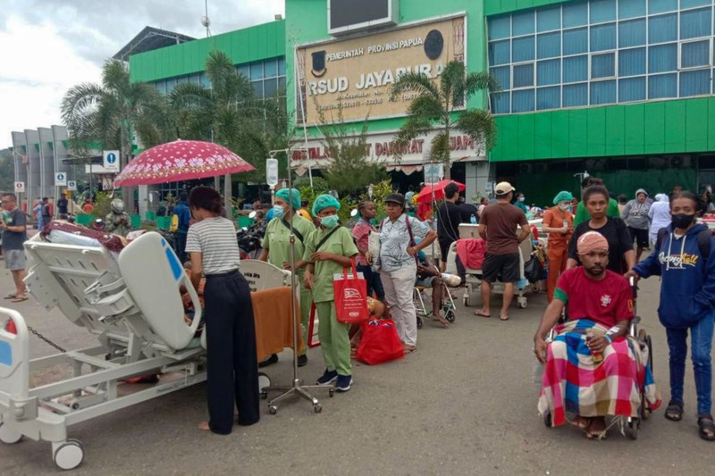 Orang-orang berdiri di atap toko yang runtuh di pelabuhan setelah gempa berkekuatan 5,1 di Jayapura, provinsi timur Indonesia Papua pada 9 Februari 2023. Orang-orang berdiri di atap toko yang runtuh di pelabuhan setelah gempa berkekuatan 5,1 di Jayapura, provinsi timur Indonesia Papua pada 9 Februari 2023. (FAISAL NARWAWAN/AFP via Getty Images)