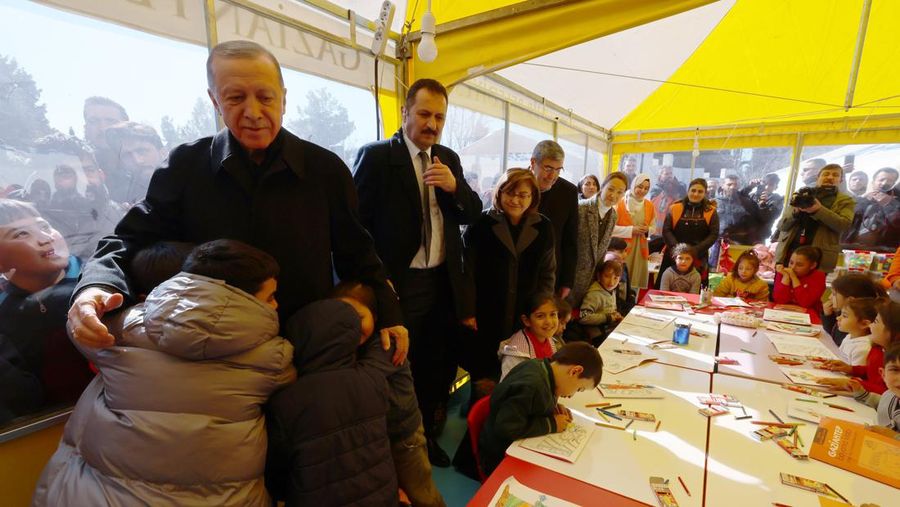 Presiden Turki Recep Tayyip Erdogan merangkul anak-anak yang terkena gempa di kota tenda yang didirikan oleh Otoritas Manajemen Bencana dan Darurat (AFAD) Turkiye setelah gempa berkekuatan 7,7 dan 7,6 skala Richter melanda beberapa provinsi di Turkiye termasuk Gaziantep, Turkiye pada 09 Februari 2023. Senin dini hari pagi hari, gempa berkekuatan 7,7 yang berpusat di distrik Pazarcik, mengguncang Kahramanmaras dan mengguncang beberapa provinsi dengan kuat, termasuk Gaziantep, Sanliurfa, Diyarbakir, Adana, Adiyaman, Malatya, Osmaniye, Hatay, dan Kilis. Kemudian, pada pukul 13.24. (1024GMT), gempa berkekuatan 7,6 yang berpusat di distrik Elbistan Kahramanmaras melanda wilayah tersebut. Turkiye mengumumkan 7 hari berkabung nasional setelah gempa bumi mematikan di provinsi selatan. (Turkish Presidency / Handout/Anadolu Agency via Getty Images)