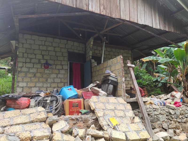 Orang-orang berdiri di atap toko yang runtuh di pelabuhan setelah gempa berkekuatan 5,1 di Jayapura, provinsi timur Indonesia Papua pada 9 Februari 2023. Orang-orang berdiri di atap toko yang runtuh di pelabuhan setelah gempa berkekuatan 5,1 di Jayapura, provinsi timur Indonesia Papua pada 9 Februari 2023. (FAISAL NARWAWAN/AFP via Getty Images)