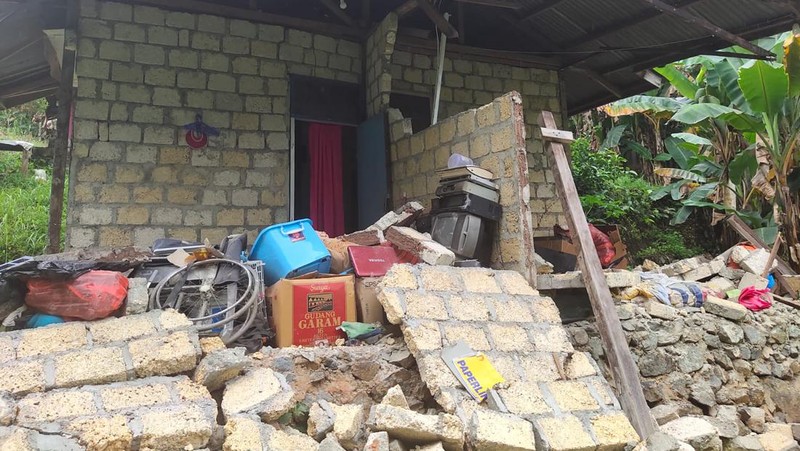 Orang-orang berdiri di atap toko yang runtuh di pelabuhan setelah gempa berkekuatan 5,1 di Jayapura, provinsi timur Indonesia Papua pada 9 Februari 2023. (FAISAL NARWAWAN/AFP via Getty Images)