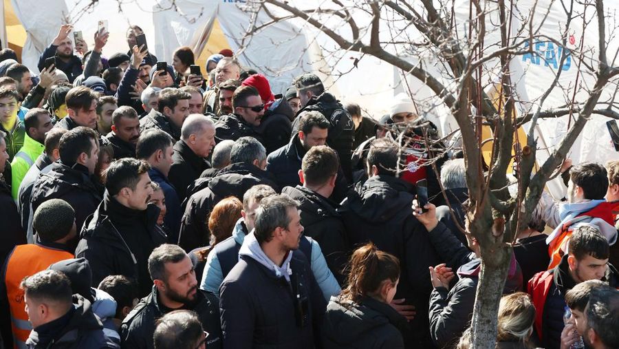 Presiden Turki Recep Tayyip Erdogan berbicara dengan warga korban gempa di kota tenda yang didirikan oleh Otoritas Manajemen Bencana dan Darurat (AFAD) Turkiye setelah gempa berkekuatan 7,7 dan 7,6 melanda beberapa provinsi Turkiye termasuk Gaziantep, Turkiye di 09 Februari 2023. (AFP/OZAN KOSE)