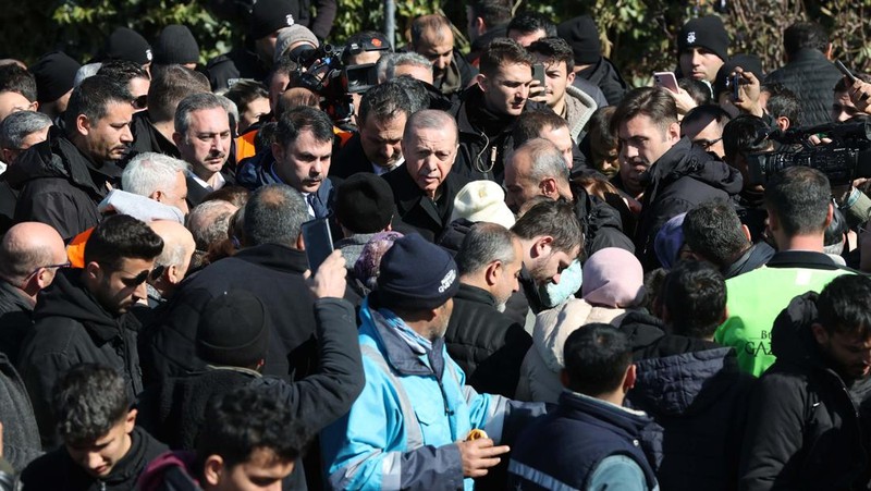 Presiden Turki Recep Tayyip Erdogan berbicara dengan warga korban gempa di kota tenda yang didirikan oleh Otoritas Manajemen Bencana dan Darurat (AFAD) Turkiye setelah gempa berkekuatan 7,7 dan 7,6 melanda beberapa provinsi Turkiye termasuk Gaziantep, Turkiye di 09 Februari 2023. (AFP/OZAN KOSE)