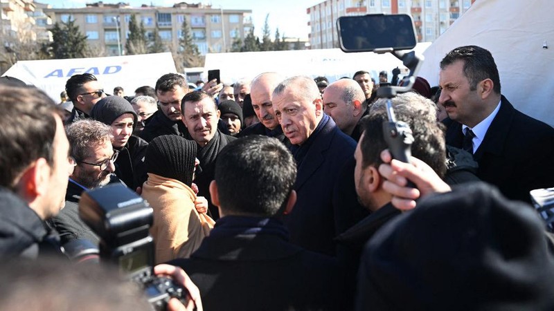 Presiden Turki Recep Tayyip Erdogan berbicara dengan warga korban gempa di kota tenda yang didirikan oleh Otoritas Manajemen Bencana dan Darurat (AFAD) Turkiye setelah gempa berkekuatan 7,7 dan 7,6 melanda beberapa provinsi Turkiye termasuk Gaziantep, Turkiye di 09 Februari 2023. (AFP/OZAN KOSE)