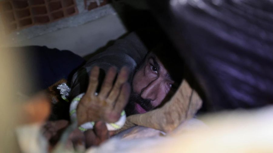 Abdulaim Muaini saat akan dievakuasi tim penyelamat di samping istrinya yang telah meninggal. (REUTERS/UMIT BEKTAS)