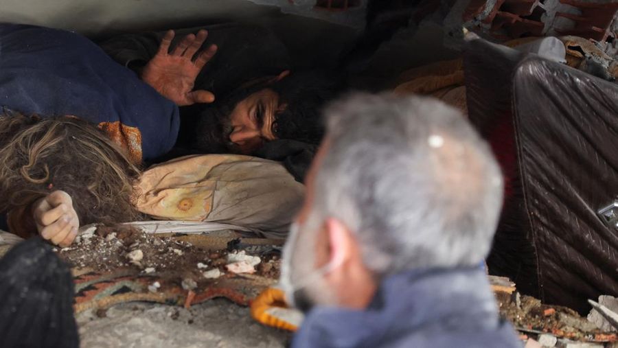 Abdulaim Muaini saat akan dievakuasi tim penyelamat di samping istrinya yang telah meninggal. (REUTERS/UMIT BEKTAS)