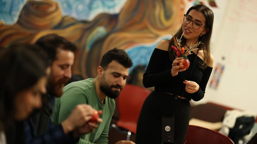 Berivan Altun, pemilik Roj Floral Studioz, mendemonstrasikan cara menghias apel dengan cengkih saat acara penggalangan dana di Universitas SOAS pada 12 Februari 2023 di London, Inggris. Kurdish House London, jaringan pengusaha Kurdi dan anak muda yang mendorong kewirausahaan dengan manfaat sosial/lingkungan, menyelenggarakan acara tradisional Seva Mexekrej sebagai acara penggalangan dana Hari Valentine untuk korban gempa Turki. Seva Mexekrej adalah tradisi Kurdi kuno di mana apel ditutupi dengan cengkih. Pemilik Berivan dari Roj Floral Studio hadir dengan sentuhan modern dengan menambahkan rangkaian bunga di bagian tengah apel. Masyarakat Kurdi Universitas SOAS mengadakan acara untuk menyatukan orang-orang dari keempat wilayah Kurdi tanpa agenda politik atau agama untuk berbagi tradisi ini. Hasil dari penggalangan dana akan disumbangkan ke Heyva Sor yang juga dikenal sebagai Bulan Merah Kurdi. (Hollie Adams/Getty Images)