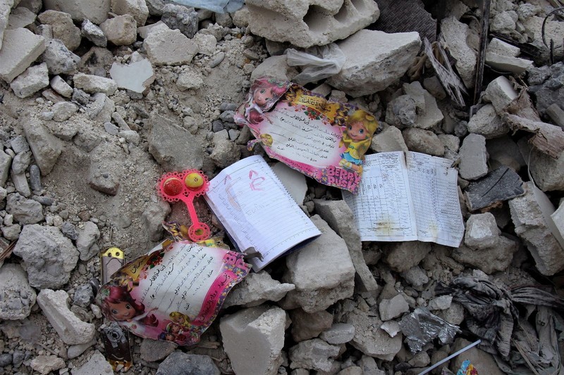 Seorang anggota White Helmets melihat buku catatan yang ditemukan di sebuah bangunan yang rusak, setelah gempa bumi, di kota Jandaris yang dikuasai pemberontak, Suriah, 10 Februari 2023. (White Helmets/Handout via REUTERS)