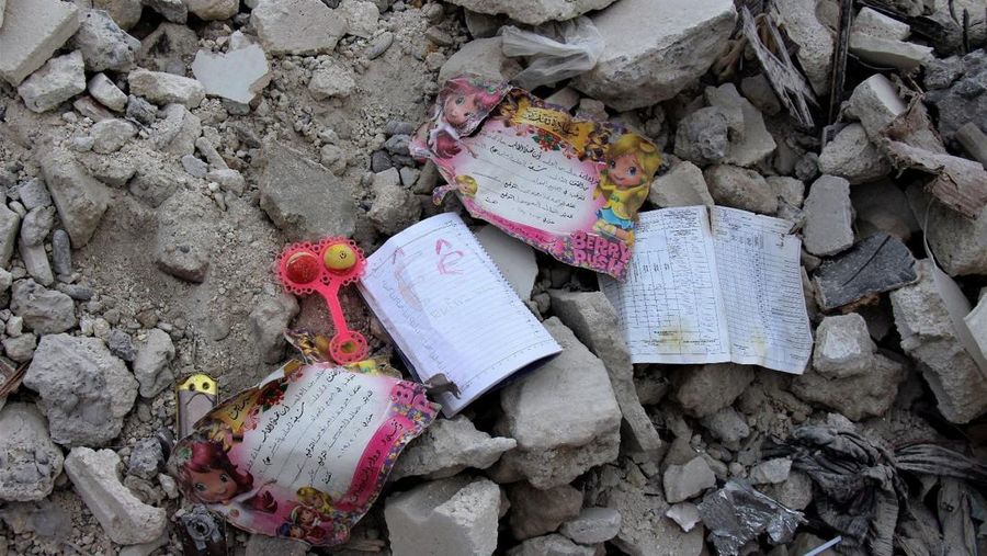 Seorang anggota White Helmets melihat buku catatan yang ditemukan di sebuah bangunan yang rusak, setelah gempa bumi, di kota Jandaris yang dikuasai pemberontak, Suriah, 10 Februari 2023. (White Helmets/Handout via REUTERS)