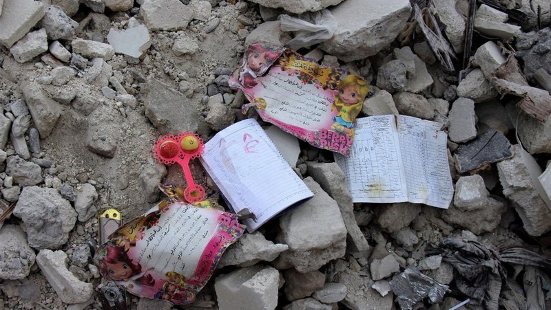 Seorang anggota White Helmets melihat buku catatan yang ditemukan di sebuah bangunan yang rusak, setelah gempa bumi, di kota Jandaris yang dikuasai pemberontak, Suriah, 10 Februari 2023. (White Helmets/Handout via REUTERS)