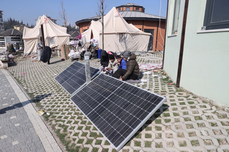 Para penyintas gempa memenuhi kebutuhan energi mendesak mereka dengan panel surya yang dipasang di kota tenda setelah gempa berkekuatan 7,7 dan 7,6 di Hatay, Turkiye pada 12 Februari 2023. Senin dini hari, gempa berkekuatan 7,7 SR, berpusat di distrik Pazarcik, mengguncang Kahramanmaras dan berguncang kuat beberapa provinsi, termasuk Gaziantep, Sanliurfa, Diyarbakir, Adana, Adiyaman, Malatya, Osmaniye, Hatay, dan Kilis. Kemudian, pada pukul 13.24. (1024GMT), gempa berkekuatan 7,6 yang berpusat di distrik Elbistan Kahramanmaras melanda wilayah tersebut. Turkiye mengumumkan 7 hari berkabung nasional setelah gempa bumi mematikan di provinsi selatan. (Oguz Yeter/Anadolu Agency via Getty Images)