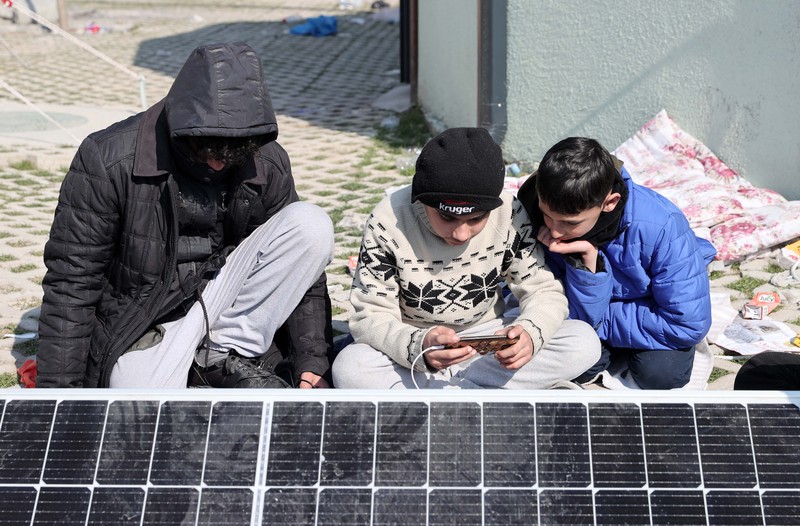 Para penyintas gempa memenuhi kebutuhan energi mendesak mereka dengan panel surya yang dipasang di kota tenda setelah gempa berkekuatan 7,7 dan 7,6 di Hatay, Turkiye pada 12 Februari 2023. Senin dini hari, gempa berkekuatan 7,7 SR, berpusat di distrik Pazarcik, mengguncang Kahramanmaras dan berguncang kuat beberapa provinsi, termasuk Gaziantep, Sanliurfa, Diyarbakir, Adana, Adiyaman, Malatya, Osmaniye, Hatay, dan Kilis. Kemudian, pada pukul 13.24. (1024GMT), gempa berkekuatan 7,6 yang berpusat di distrik Elbistan Kahramanmaras melanda wilayah tersebut. Turkiye mengumumkan 7 hari berkabung nasional setelah gempa bumi mematikan di provinsi selatan. (Oguz Yeter/Anadolu Agency via Getty Images)