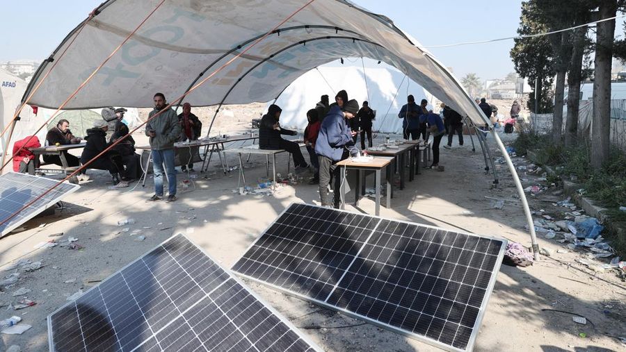 Para penyintas gempa memenuhi kebutuhan energi mendesak mereka dengan panel surya yang dipasang di kota tenda setelah gempa berkekuatan 7,7 dan 7,6 di Hatay, Turkiye pada 12 Februari 2023. Senin dini hari, gempa berkekuatan 7,7 SR, berpusat di distrik Pazarcik, mengguncang Kahramanmaras dan berguncang kuat beberapa provinsi, termasuk Gaziantep, Sanliurfa, Diyarbakir, Adana, Adiyaman, Malatya, Osmaniye, Hatay, dan Kilis. Kemudian, pada pukul 13.24. (1024GMT), gempa berkekuatan 7,6 yang berpusat di distrik Elbistan Kahramanmaras melanda wilayah tersebut. Turkiye mengumumkan 7 hari berkabung nasional setelah gempa bumi mematikan di provinsi selatan. (Oguz Yeter/Anadolu Agency via Getty Images)