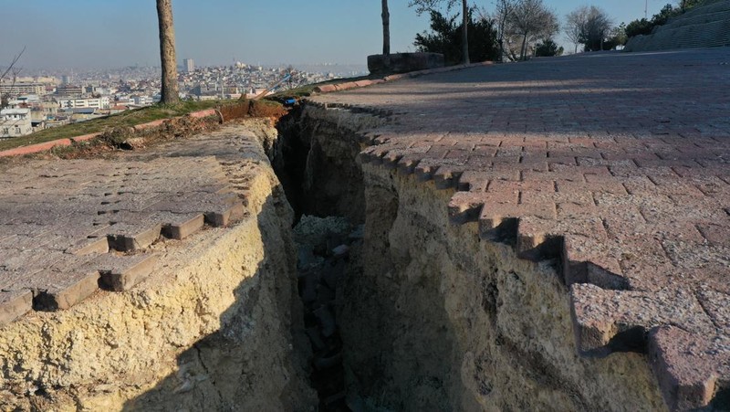 Pemandangan udara menyelam di Taman Aydinbaba dan membentuk lubang setelah gempa berkekuatan 7,7 dan 7,6 melanda beberapa provinsi di Turkiye termasuk Gaziantep pada 12 Februari 2023. Senin dini hari, gempa berkekuatan 7,7 yang kuat, berpusat di distrik Pazarcik, mengguncang Kahramanmaras dan berguncang kuat beberapa provinsi, termasuk Gaziantep, Sanliurfa, Diyarbakir, Adana, Adiyaman, Malatya, Osmaniye, Hatay, dan Kilis. Kemudian, pada pukul 13.24. (1024GMT), gempa berkekuatan 7,6 yang berpusat di distrik Elbistan Kahramanmaras melanda wilayah tersebut. Turkiye mengumumkan 7 hari berkabung nasional setelah gempa bumi mematikan di provinsi selatan. (Mehmet Akif Parlak/Anadolu Agency via Getty Images)