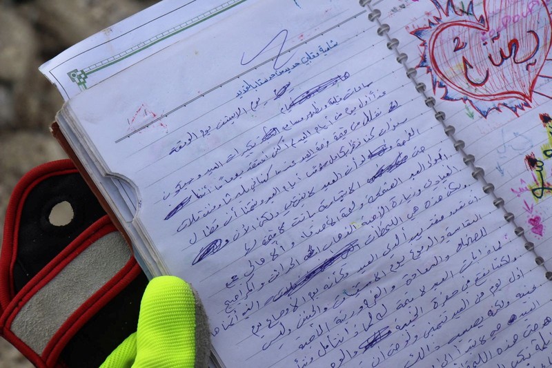 Seorang anggota White Helmets melihat buku catatan yang ditemukan di sebuah bangunan yang rusak, setelah gempa bumi, di kota Jandaris yang dikuasai pemberontak, Suriah, 10 Februari 2023. Seorang anggota White Helmets melihat buku catatan yang ditemukan di sebuah bangunan yang rusak, setelah gempa bumi, di kota Jandaris yang dikuasai pemberontak, Suriah, 10 Februari 2023. (White Helmets/Handout via REUTERS)