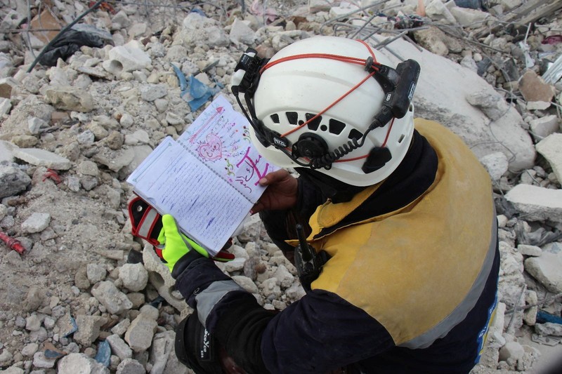 Seorang anggota White Helmets melihat buku catatan yang ditemukan di sebuah bangunan yang rusak, setelah gempa bumi, di kota Jandaris yang dikuasai pemberontak, Suriah, 10 Februari 2023. Seorang anggota White Helmets melihat buku catatan yang ditemukan di sebuah bangunan yang rusak, setelah gempa bumi, di kota Jandaris yang dikuasai pemberontak, Suriah, 10 Februari 2023. (White Helmets/Handout via REUTERS)